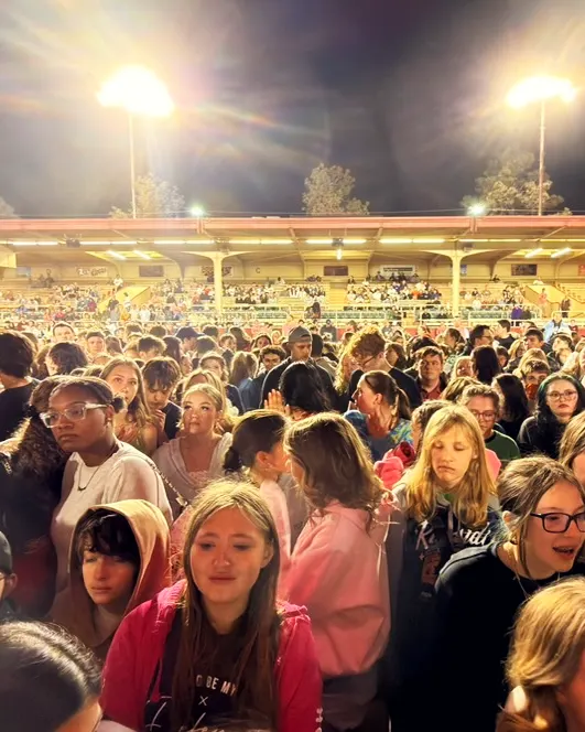Students together under the arena lights at the end of the night