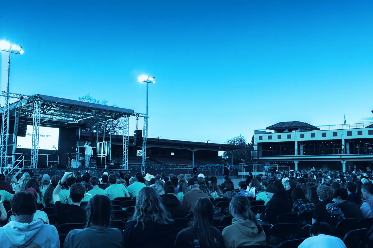 Students filling the arena at Norris Penrose Event Center at dusk during One Big Wednesday 2026, with the stage on the left